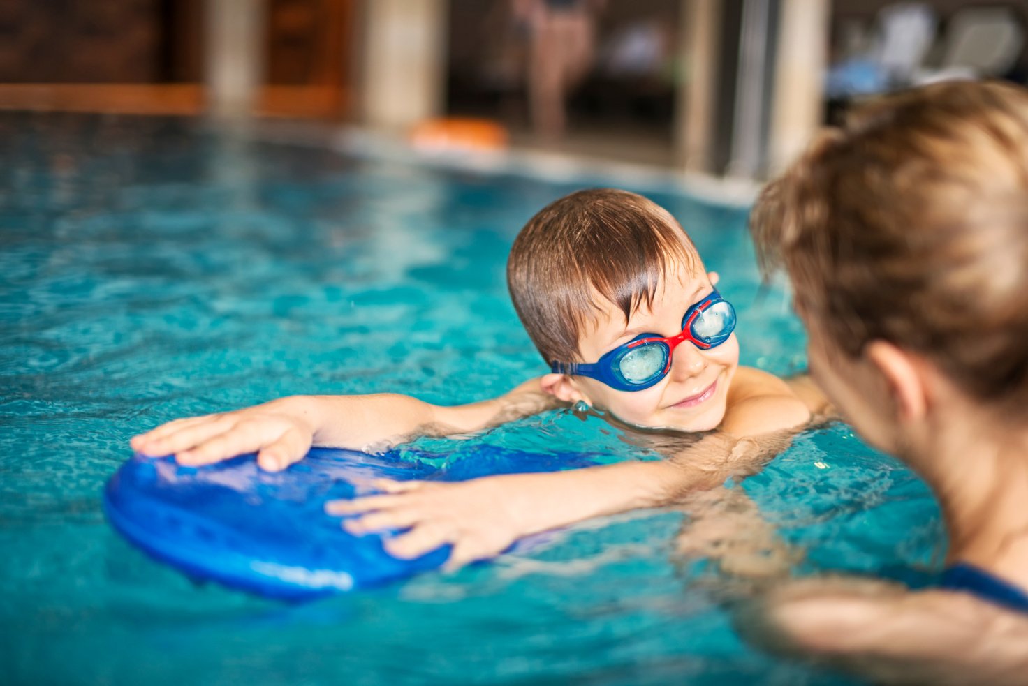 Little boy during swimming lesson at indoors swimming pool